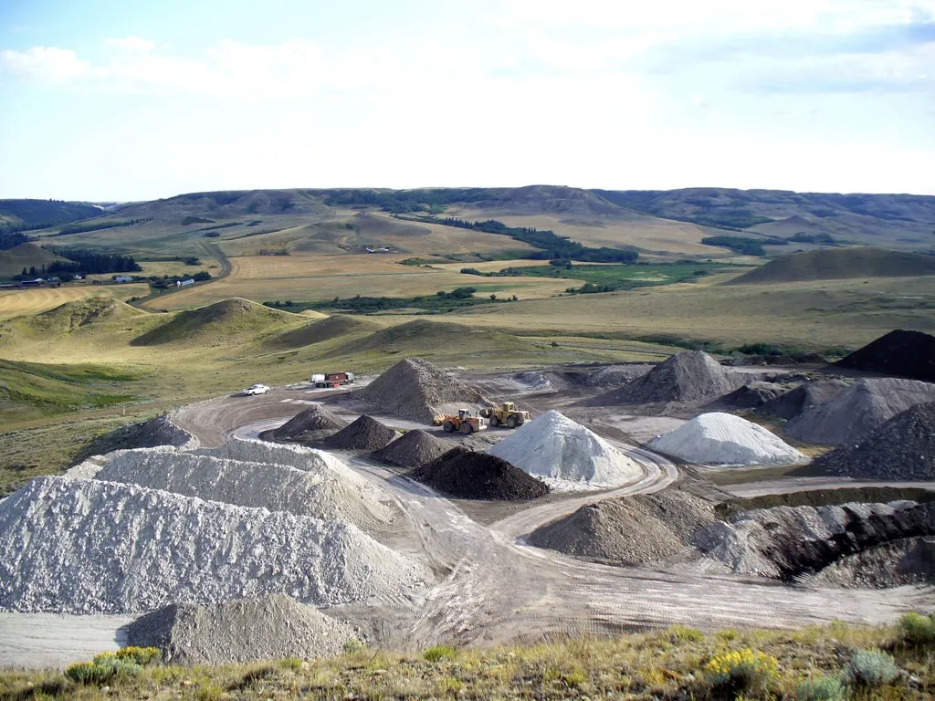 Stockpiles of clay and wheel loaders on the flattened hill