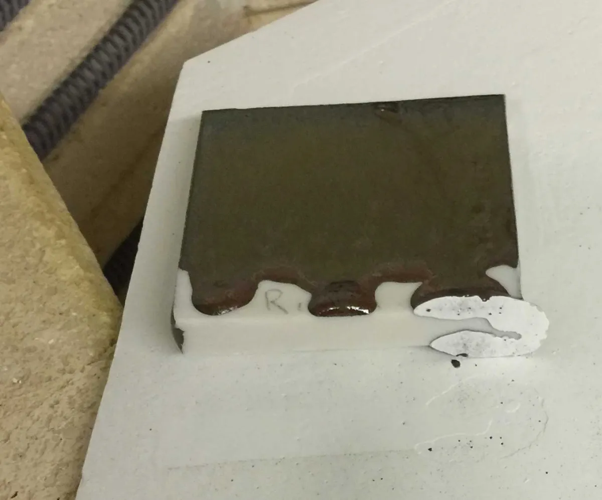 A running glaze has stuck to a kiln shelf. Kiln wash saves the day!