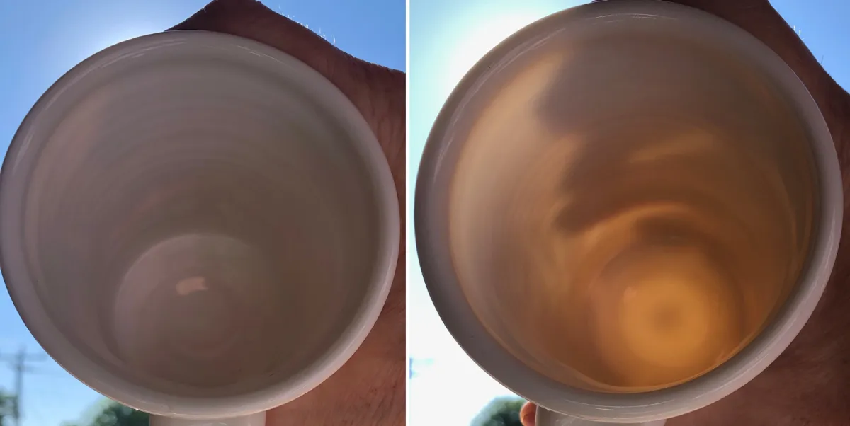 Two mugs in hand, blocking the sun, to compare their translucency