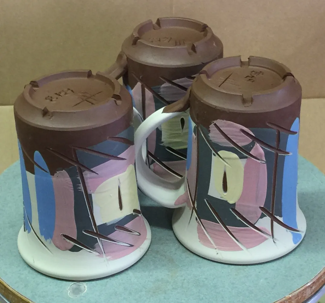 Terra Cotta mugs after under-glazing and incising
