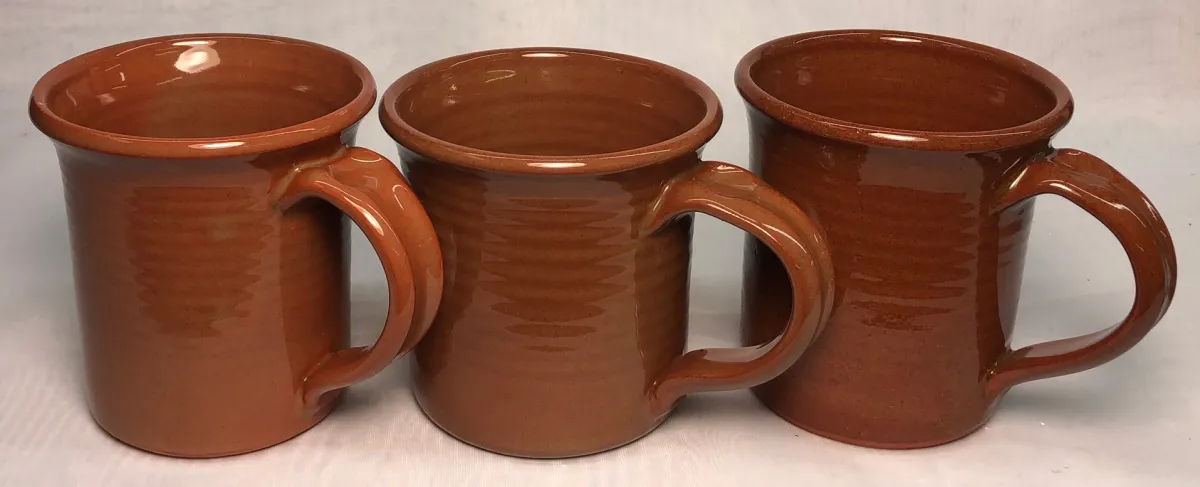 Three clear-glaze terra cotta mugs with rich red color
