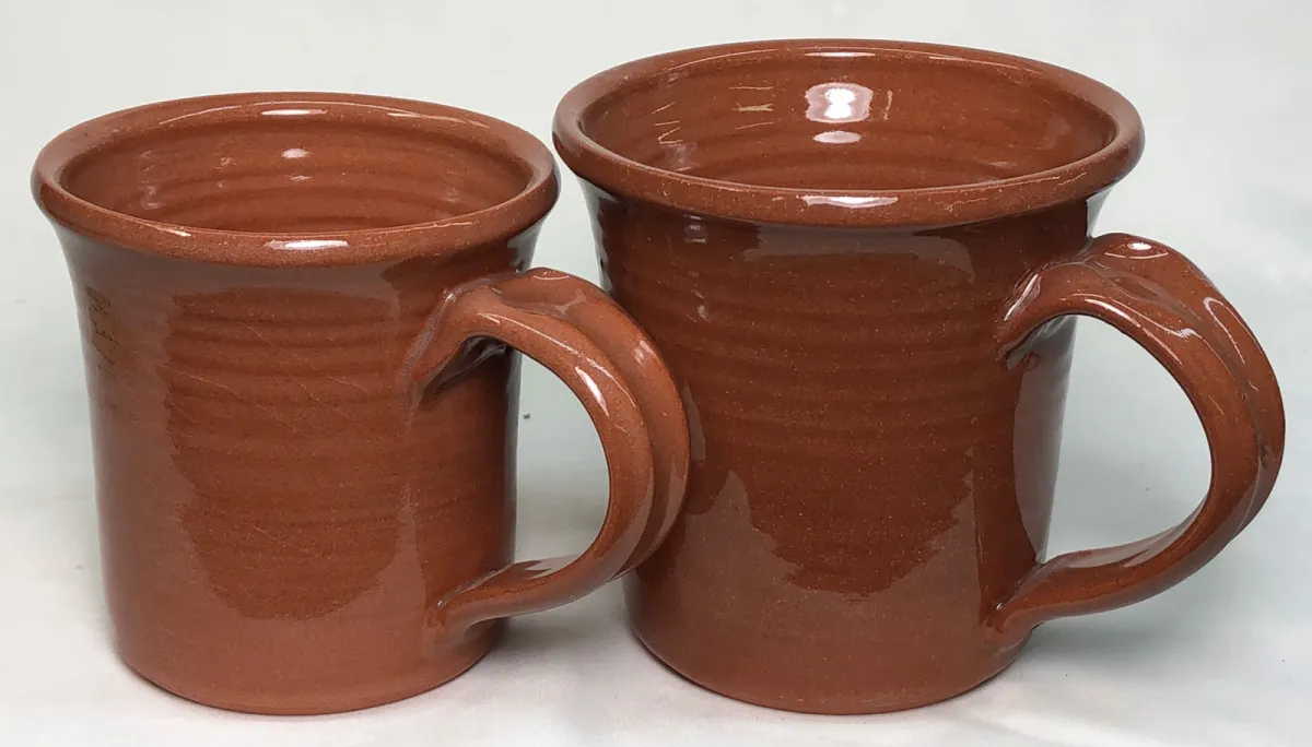 Two terra cotta mugs, the glaze on one is more glossy and the body color is richer
