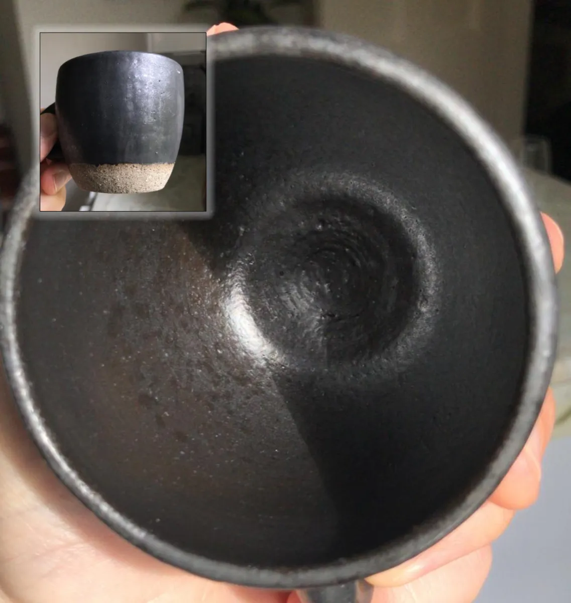 A matte black coffee mug with leaching glaze