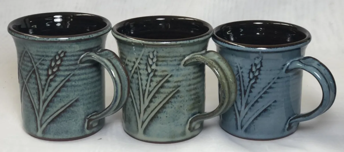 Three mugs with floating blue glazes