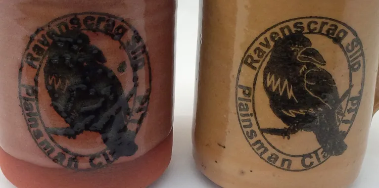 Two ceramic mugs with a rubber-stamped logo using a stain/glycerine ink