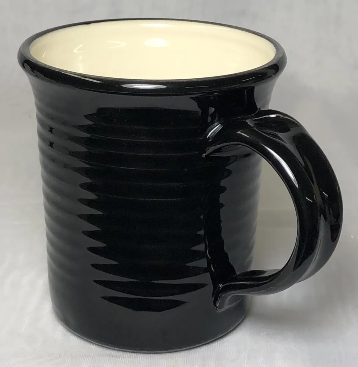 A black coffee mug with clear liner glaze