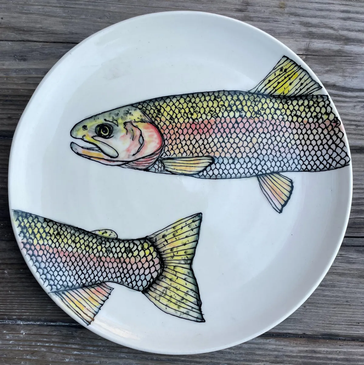 A cone 6 plate with underglaze fish design