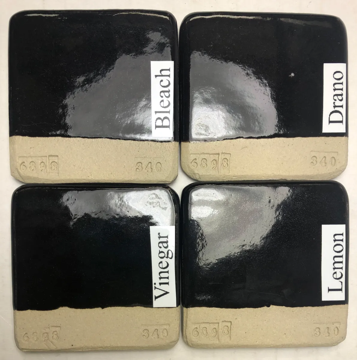 Four black-glazed test tiles