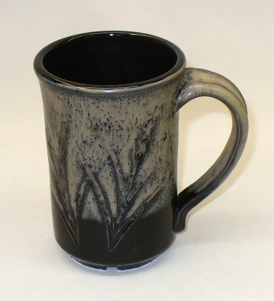 Ravenscrag oatmeal layered over black at cone 6