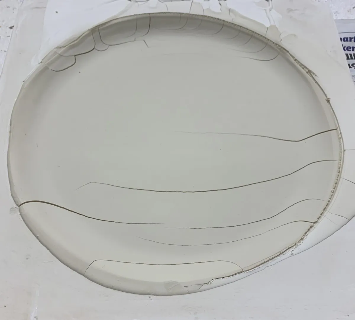 A leather hard plate cracked in the plastic mold