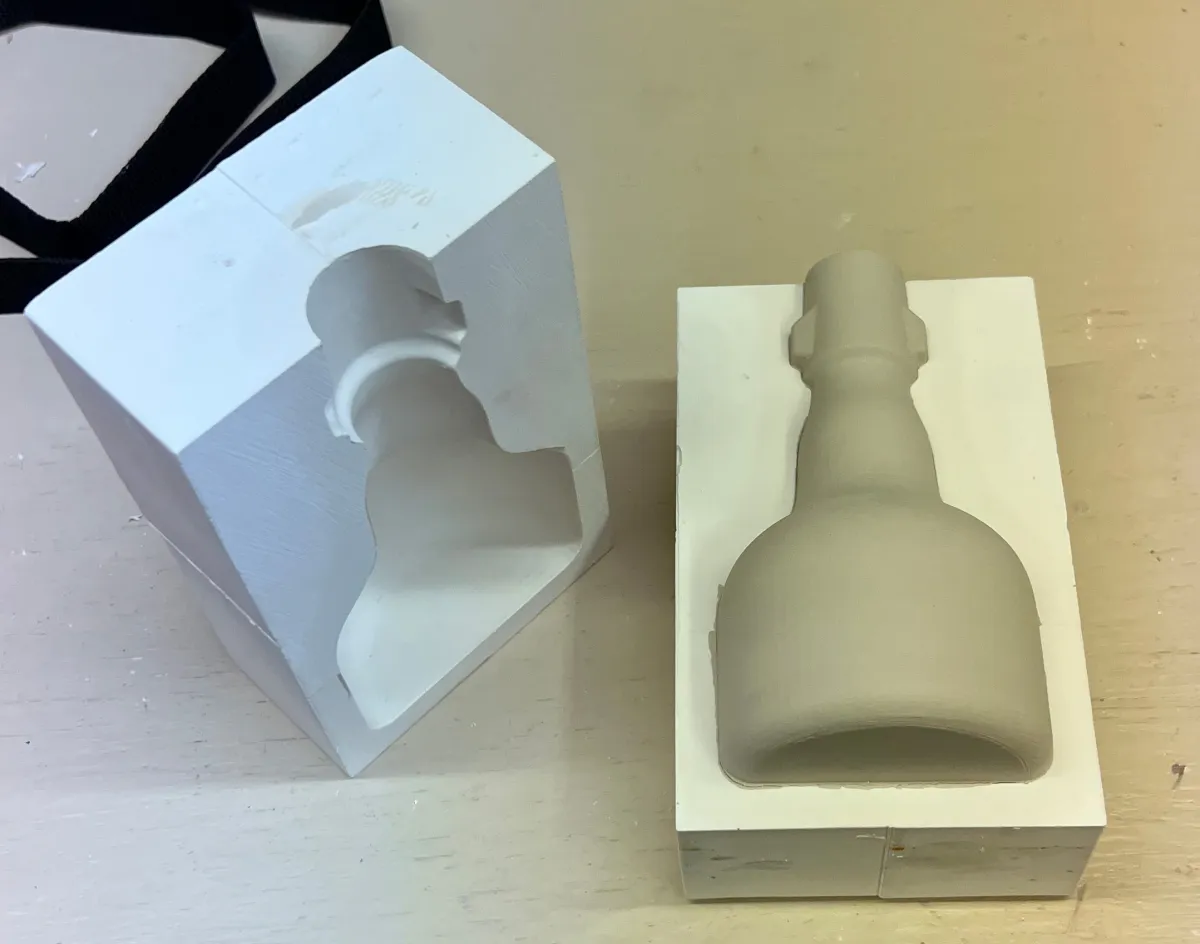 A small cast beer bottle still in the mold